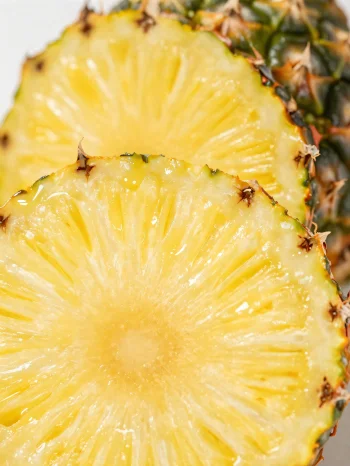 Färsk, skivad ananas på ett rustikt träbord