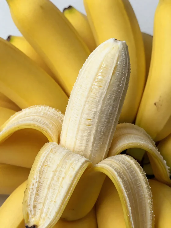Färsk banan hel och skivad, i skål och på ett rustikt bord