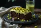 Pistage- och chokladtårta dekorerad med choklad och pistasch