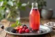 Probiotisk fruktsmaksatt kombucha serverad i flaska med färgglada fruktbitar