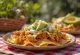 Chilaquiles med kyckling enchilada, tortillastrimlor, enchiladasås, kyckling, avokado, ost och korianderdekoration
