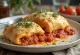 Stromboli serverad med tomatsås, rik tomatsås och smält mozzarella på toppen, krispig utsida och mjuk insida.