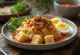 Lontong med sambalsås, serverad med färskt ägg