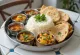 Thali-måltid med olika rätter som basmatiris, kikärtscurry, grönsaker, papadum och myntachutney